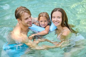 cute-girl-her-parents-spending-time-swimming-pool