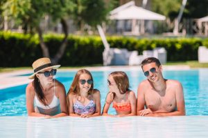 happy-family-four-outdoors-swimming-pool